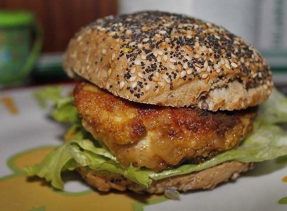 hamburguesa de pollo adobado y rebozado en un pan de semillas blancas y negras