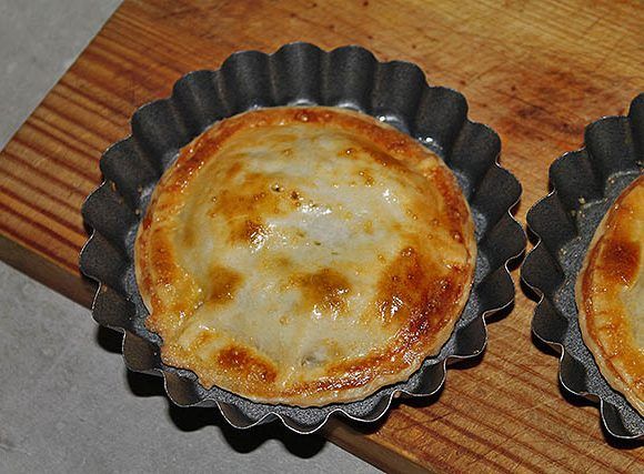 empanada redonda recién horneada rellena de salmón y brócoli